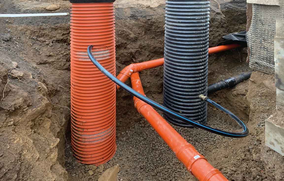 Flera dräneringsrör i marken för dränering av källare.